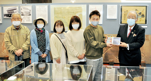 小河副実行委員長(右)から記念品を受け取る菅野さん(右から2人目)