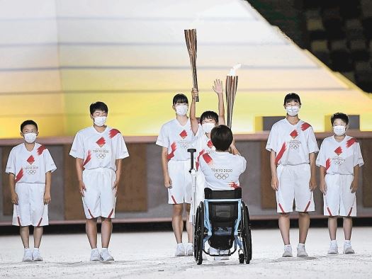 東京五輪の開会式で、聖火を受け取る子どもたち=23日夜、国立競技場