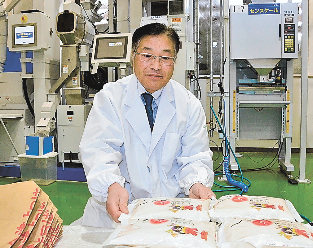 精米したばかりの「いなわしろ天のつぶ」にそっと手を置く土屋さん