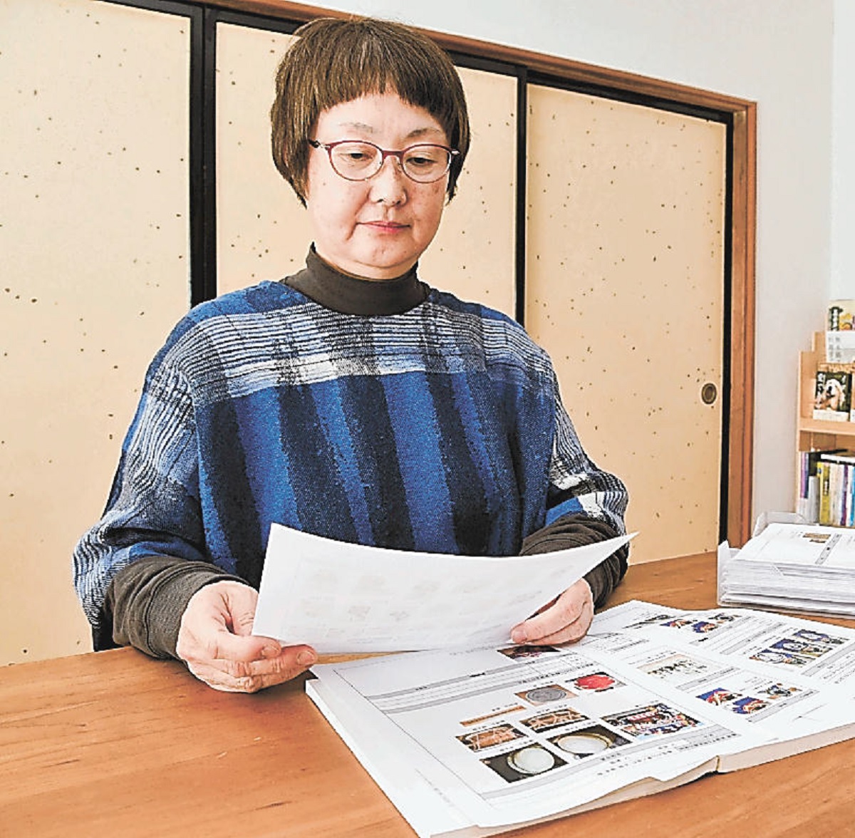 県内の民俗芸能についてまとめた資料を読む国分さん