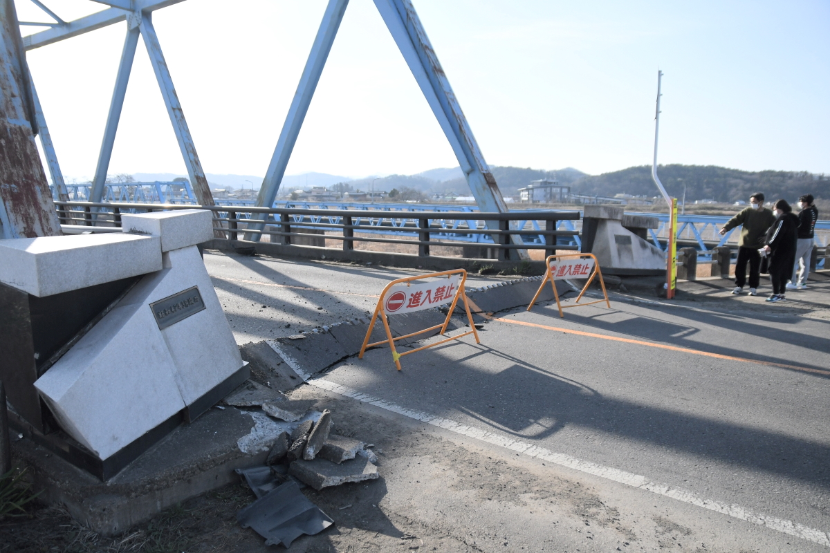 接合部の路面が盛り上がり、大きな段差が発生した伊達橋の西側。全面通行止めとなっている=17日午前7時40分ごろ、伊達市
