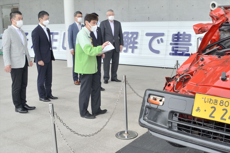 東日本大震災・原子力災害伝承館で震災の津波で変形した消防車を視察する各県の知事ら。右は鈴木副知事