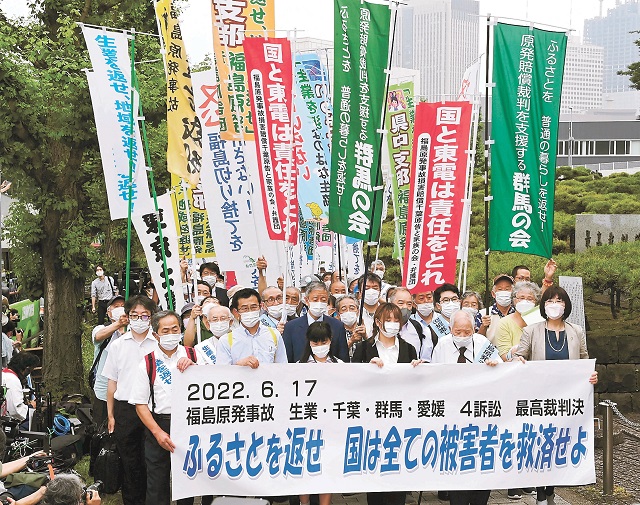 横断幕を掲げ、最高裁の前を行進する原告団=17日午後1時15分ごろ