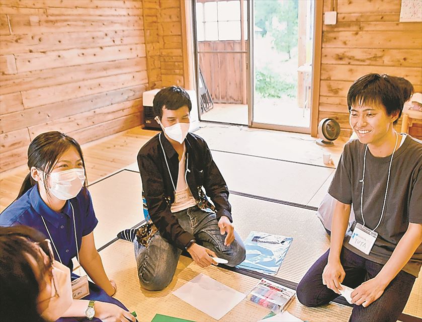 留学体験プログラムで留学生と会話する野地さん(右)