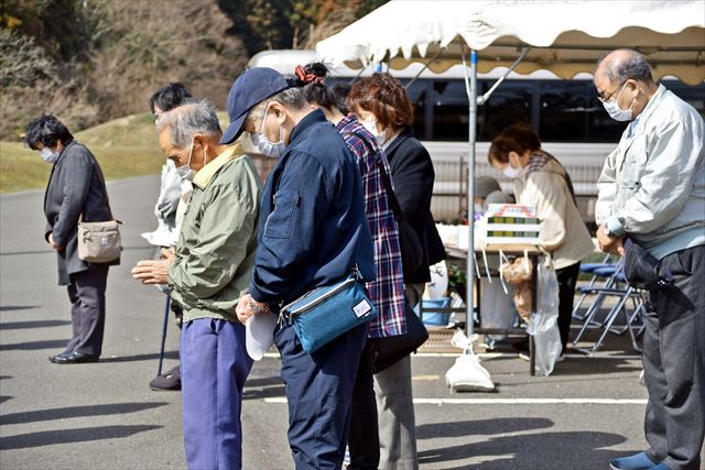 慰霊碑を前に、黙とうする出席者
