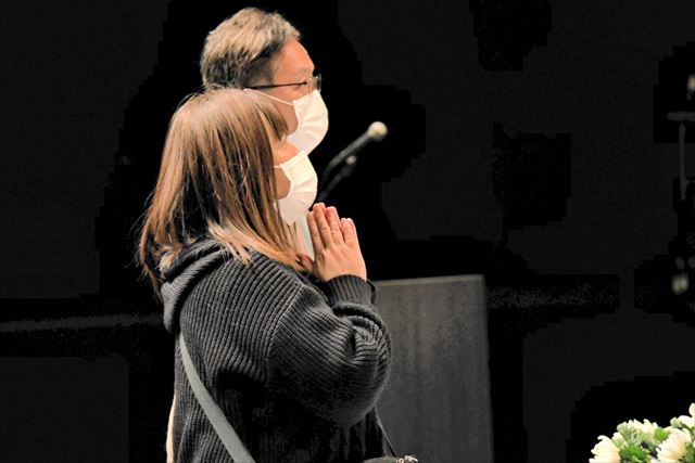 献花台に花を手向け、手を合わせる参列者=いわき市