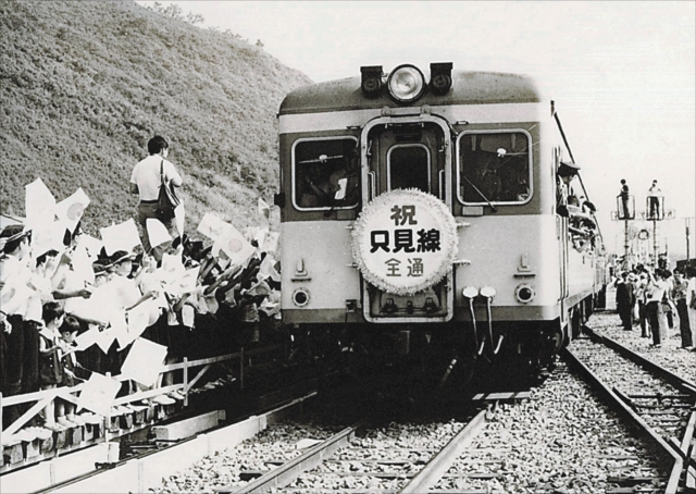 たくさんの小旗が振られる中、只見駅から小出駅に向かって出発する祝賀列車=1971年8月29日