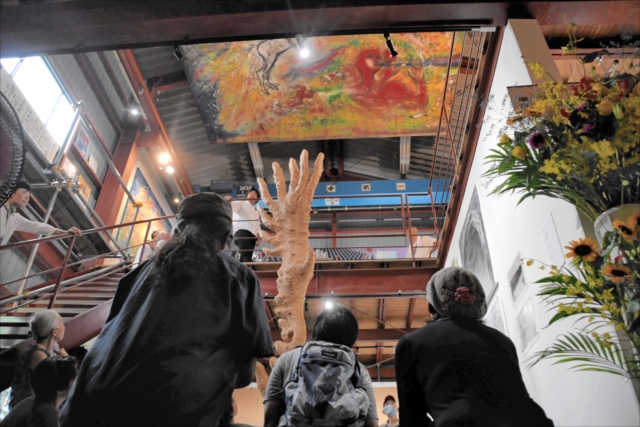 12日に開館した「おれたちの伝承館」の様子。木彫品が2階へ伸び、天井にも大きな絵画が展示されている