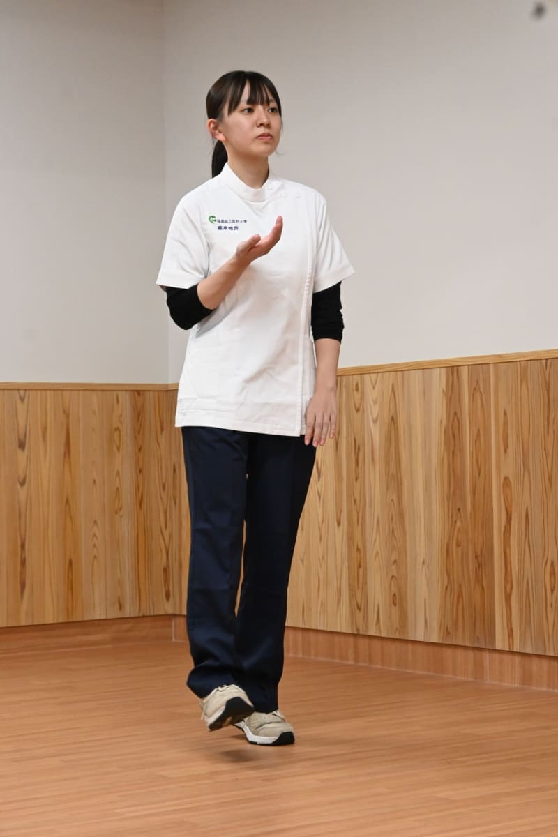 ①骨盤引き上げ歩きに、腕の動きを加える。骨盤を引き上げる際に同じ側の腕も同時に上に動かす