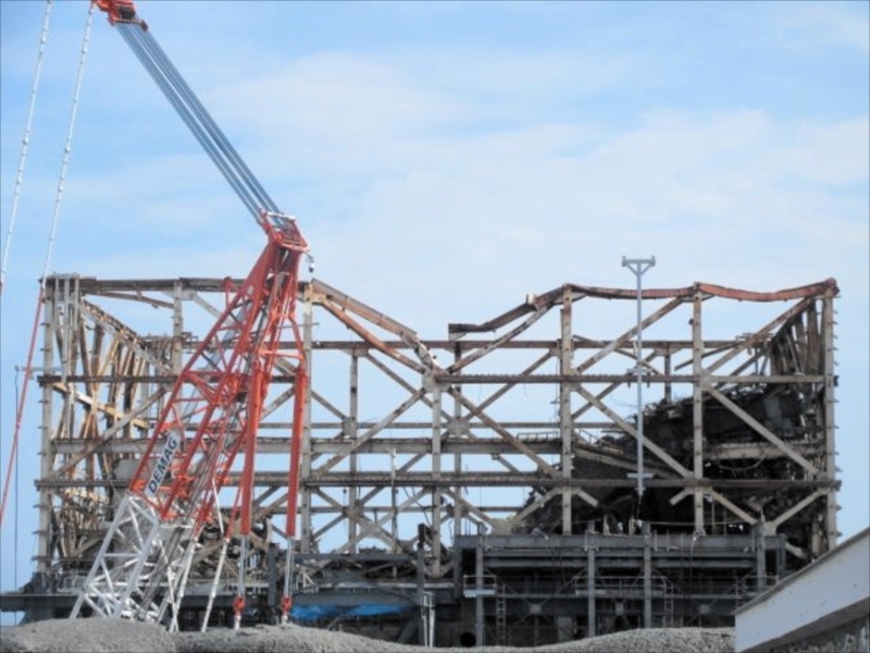 東京電力福島第1原発1号機では、建屋を覆うカバーの設置が進められている一方、ひしゃげた鉄骨はむき出しのままだ(東京電力ホールディングス提供)