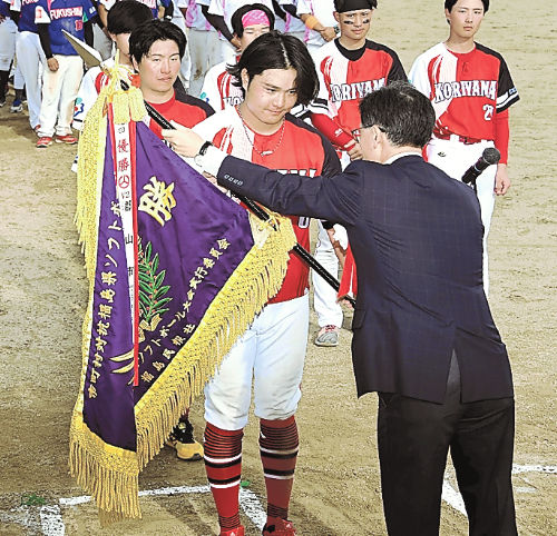 鎌田取締役から優勝旗を受け取る郡山市の関沼