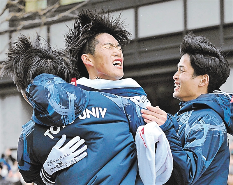 総合9位でフィニッシュし、仲間と抱き合う東洋大10区の薄根(中央)