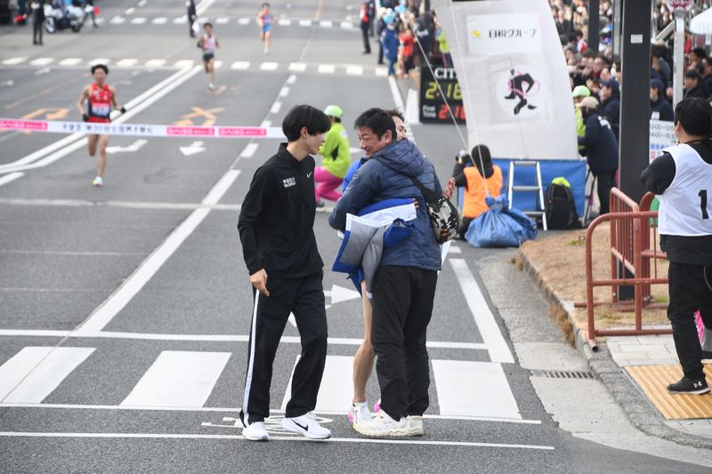 フィニッシュ地点でアンカー山口をねぎらう佐藤監督(手前)