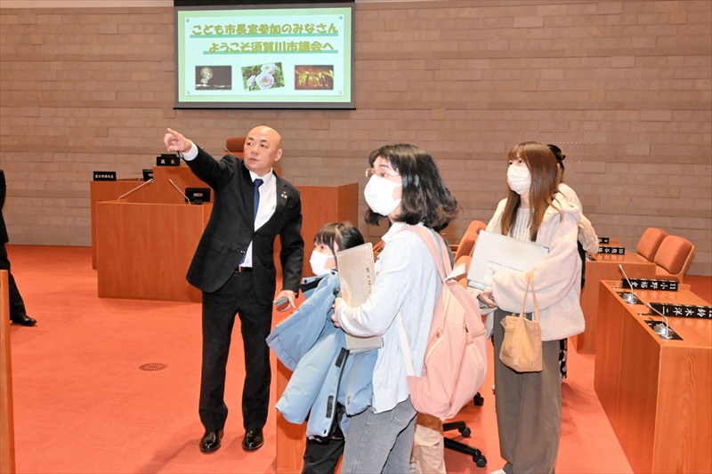 議場内を案内する大寺市長(左)と見学する参加者