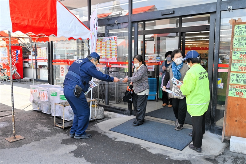 買い物客らに啓発チラシを配布する署員と会員