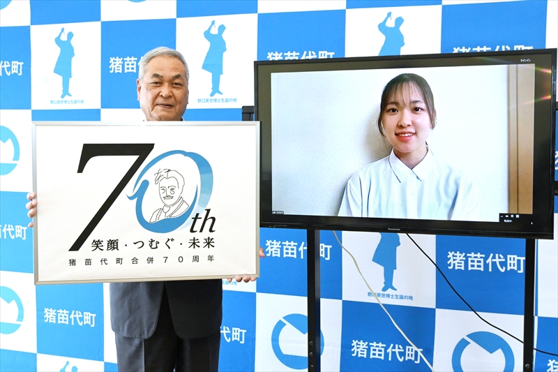 ロゴマークを掲げる二瓶町長(左)と考案した小室さん