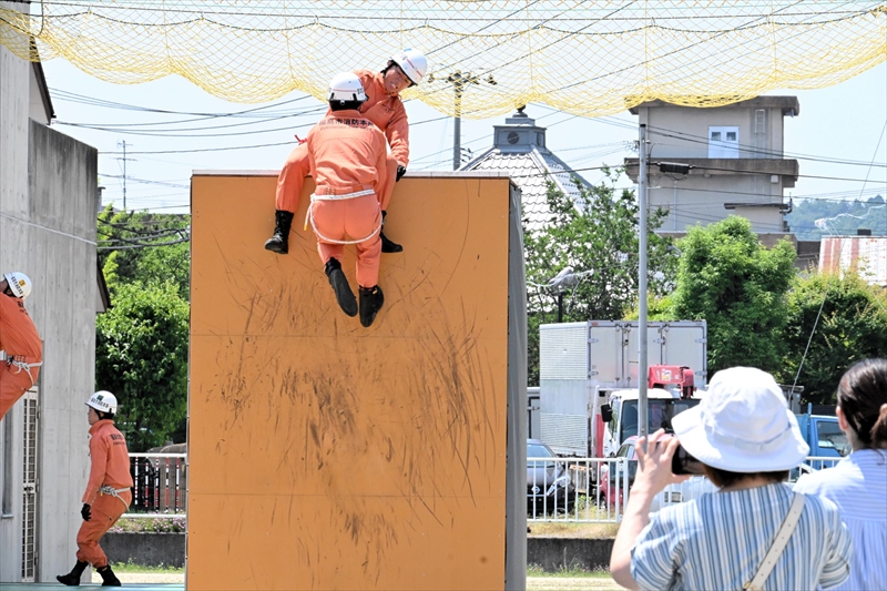 高塀などの障害を乗り越える選手