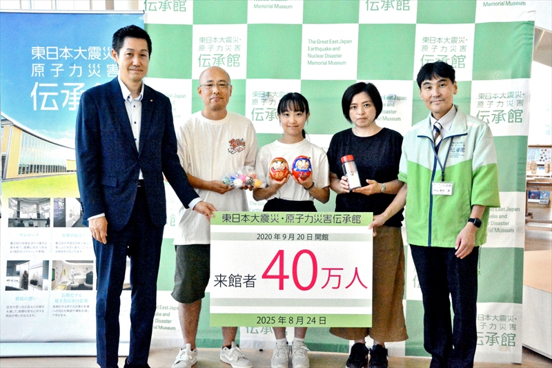 来館者40万人目の門脇さん一家(中央)。右は高村館長、左は森副町長