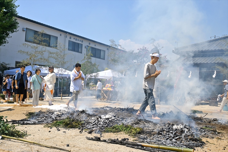 護摩檀の上を合掌しながらはだしで歩く参拝者