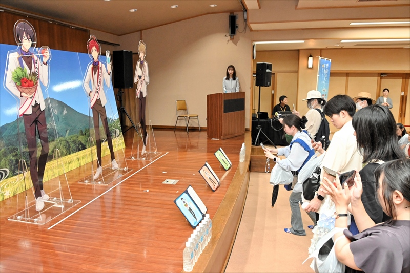 「ばんだい名水大使」に就いた3人のパネルの前で写真を撮る来場者(右)