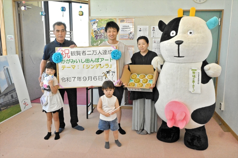 和田委員長(後列左)から記念品を受け取った先崎さん一家