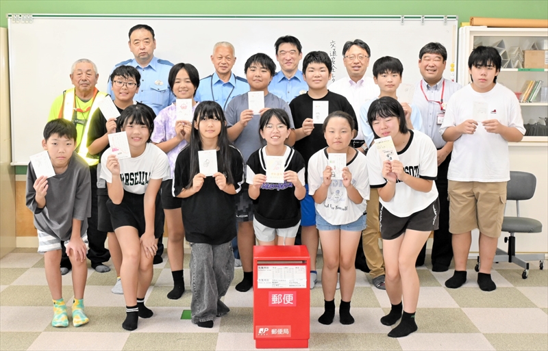 交通安全を訴えるはがきを手にする児童ら