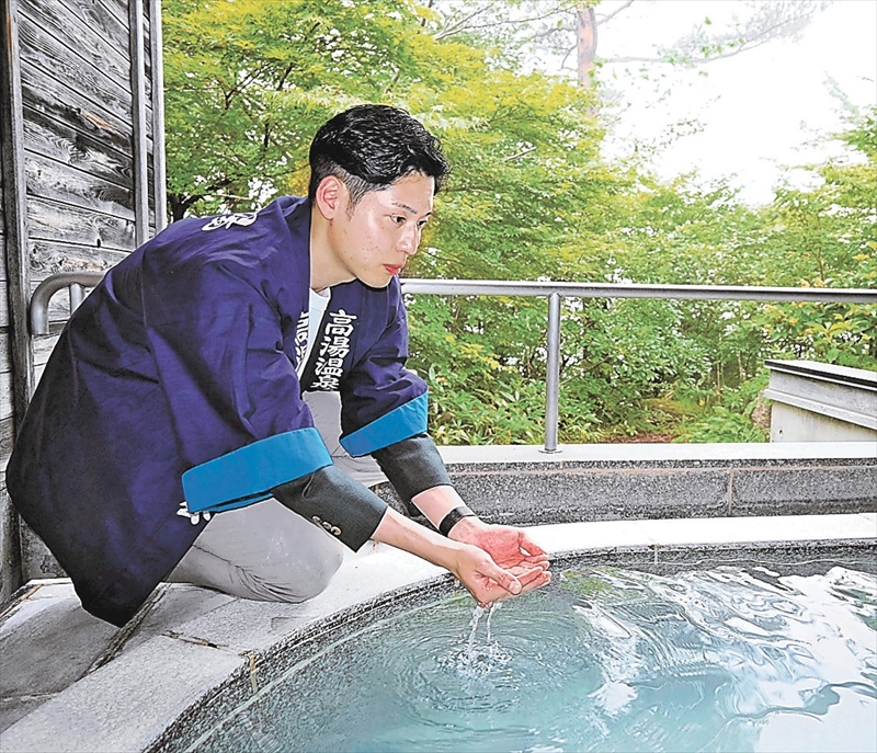 硫黄泉の白濁した湯を手にすくい、亡き父と従業員に思いをはせる要人さん