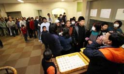 川俣町の避難所で、炊き出しのおにぎりを待つ浜通りからの避難者＝昨年３月１３日、川俣町提供