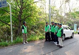 １１４号国道の川俣町と浪江町との境を巡回する地域安全パトロール隊員。行く先々で線量を確かめている＝５月２１日午後５時ごろ