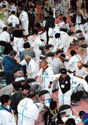 警戒区域への一時帰宅のため防護服を着る避難者。県は万が一に備え、地元の町などに配備していた＝昨年５月撮影