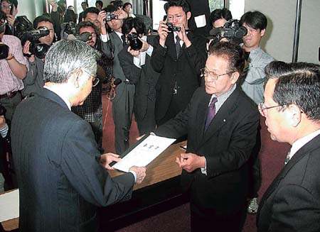  双葉町の岩本忠夫町長から原発の安全確認などの要望書を受け取る原子力安全・保安院の佐々木宜彦院長（左）＝平成１５年５月、富岡町