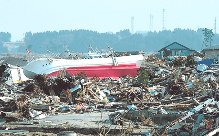 津波で大きな被害を受けた浪江町請戸地区周辺。奥には東京電力福島第一原子力発電所の排気筒が見える＝平成２３年４月撮影