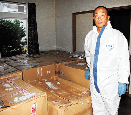 支援を受けた大量の防護服を前にする斎藤さん
