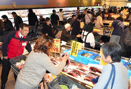 開店初日でにぎわう店内の水産品販売コーナーで声を掛ける浜名店長（左）
