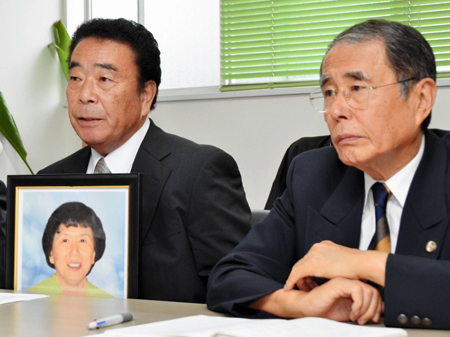はま子さんの遺影を胸に心境を語る幹夫さん（左）。右は広田弁護士