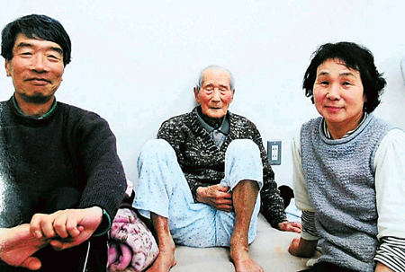 福島市の避難所にいたころの大場さん（中央）と俊明さん（左）、絹子さん（右）。大場さんは避難所を転々とし歩けなくなった