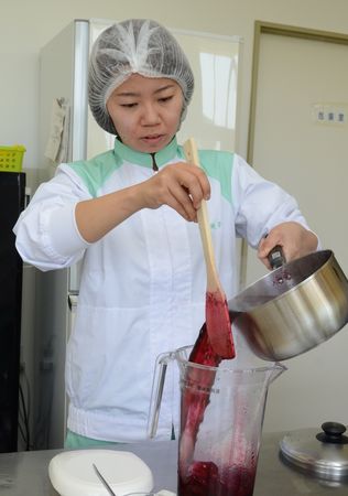 加工場でミネラル野菜のかき氷シロップの改良に取り組む仲川