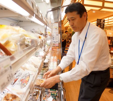 県内産の六次化商品が並ぶ棚をチェックする加藤