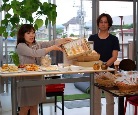 社内会議でドライフルーツ商品を示す（右から）社長の渡辺と妻の晶子